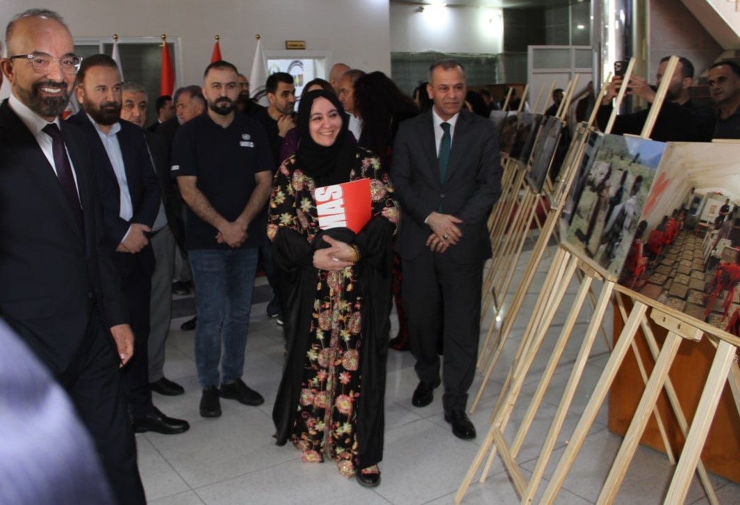 people walking with pictures on a stand besode them