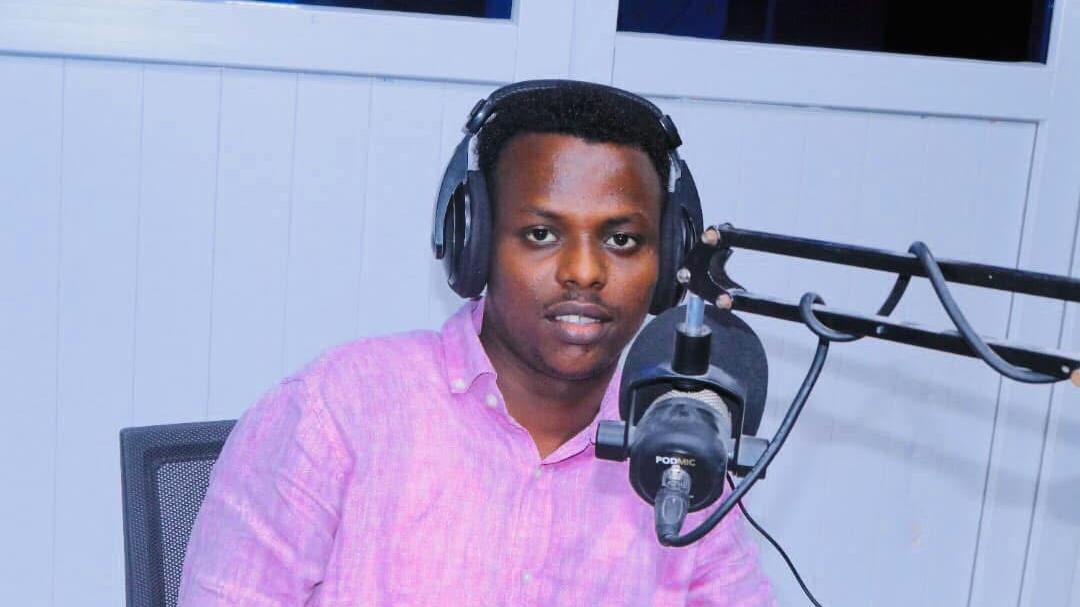 Abdishakur Abdirahman in front of a microphone wearing headphones