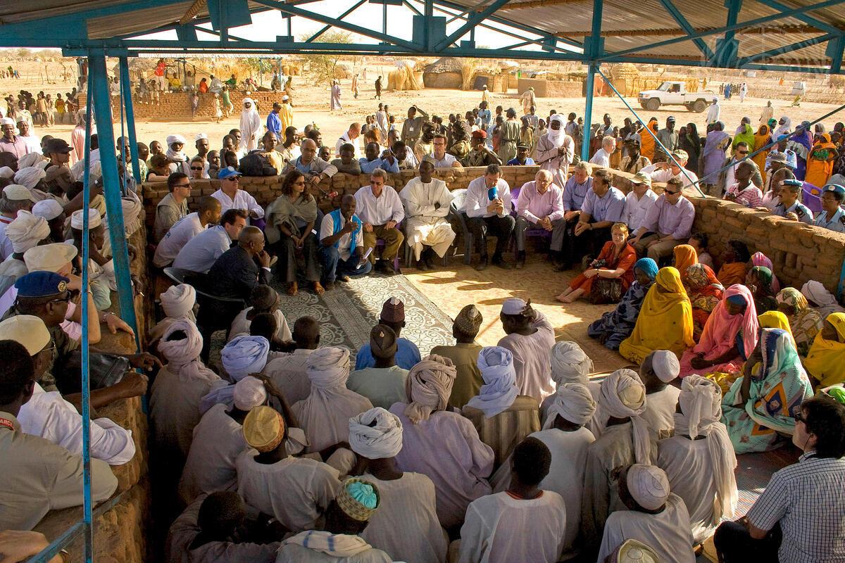 Large group of people sitting in a square all facing each other.