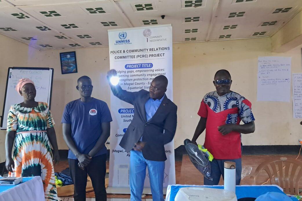 A group of people stand indoors during a UNMISS community workshop.