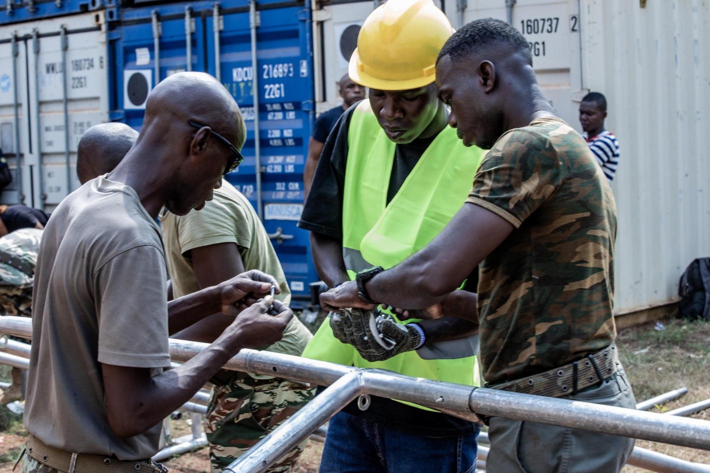 three people making a tent