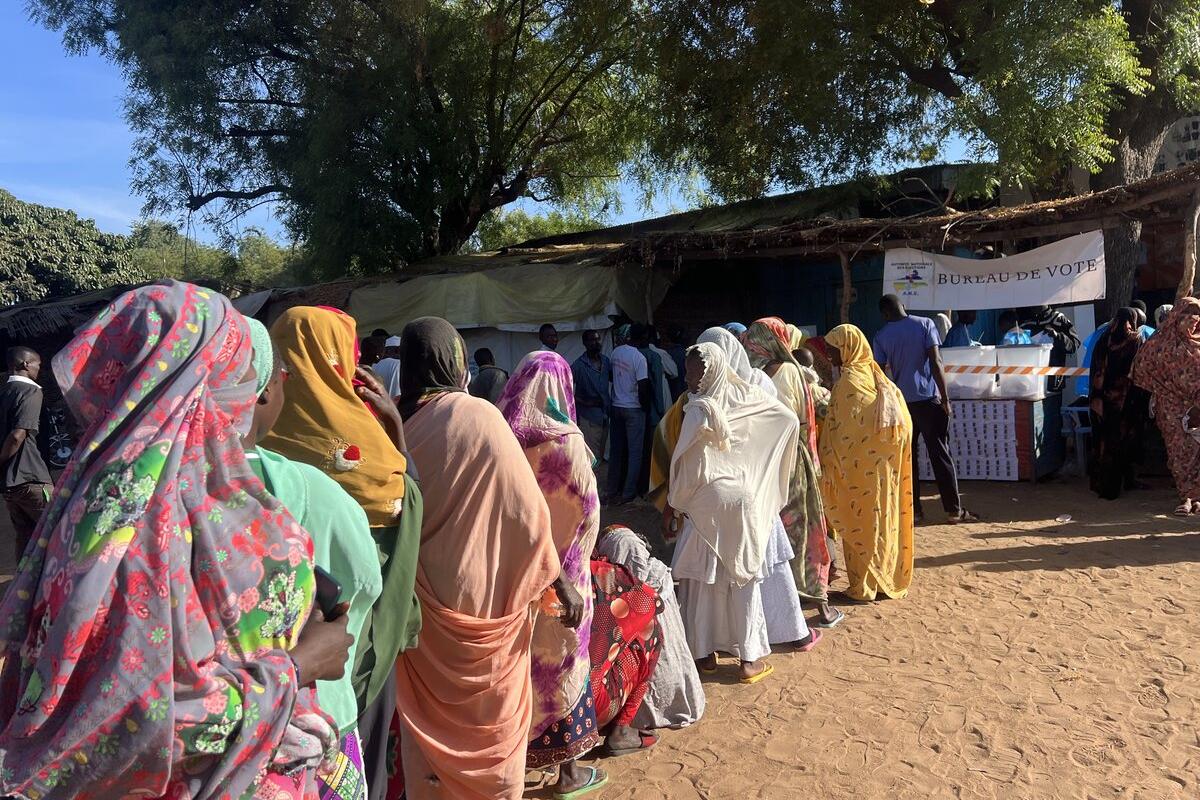 Des personnes font la queue devant un bureau de vote.