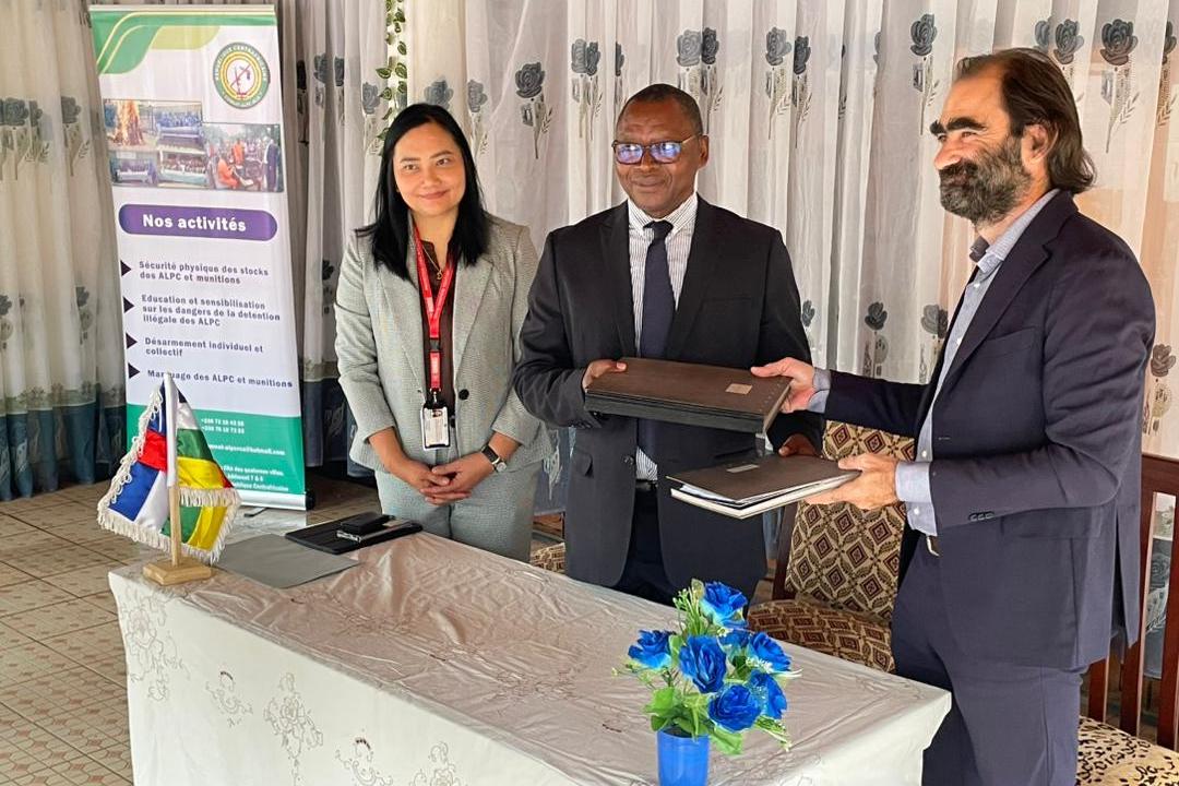 A woman is standing beside two men