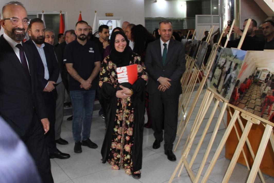 people walking with pictures on a stand besode them